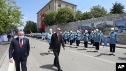 Turkey's President Recep Tayyip Erdogan, center, inspects a military honor guard as he arrives at the parliament for a ceremony, in Ankara, Turkey, July 15, 2020.