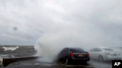 People sit in a car and watch the waves on the shore of Lake Pontchartrain as weather from Tropical Storm Cindy, in the Gulf of Mexico, impacts the region in New Orleans, June 20, 2017.