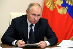 FILE - Russian President Vladimir Putin chairs a joint meeting of the country's State Council and the Council for Strategic Development and National Projects via a videoconference at Novo-Ogaryovo state residence, Dec. 23, 2020.