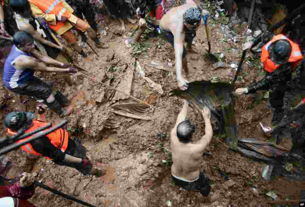 Philippine rescuers dig for survivors where four homes collapsed in a landslide incident in Quezon City, Philippines, August 7, 2012.