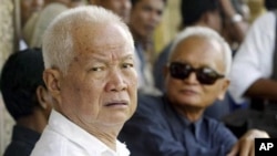 Former Khmer Rouge leaders Khieu Samphan, left, and Nuon Chea, right, look on during the funeral for Khieu Ponnary, the first wife of Khmer Rouge leader Pol Pot, in the former Khmer Rouge stronghold of Pailin, northwestern Cambodia, (File photo).