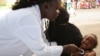 Une infirmière examine un enfant lors de tests de diagnostic de la pneumonie dans un centre de santé du quartier d'Attecoube à Abidjan, le 17 mars 2016.