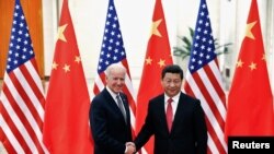 El presidente chino, Xi Jinping, le da la mano al vicepresidente de EE.UU., Joe Biden, en Beijing, China, el 4 de diciembre de 2013.