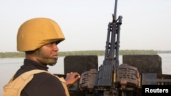 (File) A naval officer mans a machine gun boat off Nigeria's coast. Forty vessels have been attacked by armed gangs in the Gulf of Guinea this year, according to senior US military officials.