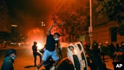 Manifestantes vandalizan vehiculos cerca de la Casa Blanca el 31 de mayo de 2020, durante las protestas por la muerte de George Floyd.