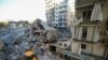Sebuah alat berat membersihkan puing-puing kantor grup keuangan Al-Qard Hassan yang terkena serangan udara Israel di pinggiran Kota Beirut, Lebanon di tengah konflik antara Israel dan Hizbullah, Senin, 21 Oktober 2024. (Foto: Ibrahim Amro/AFP)