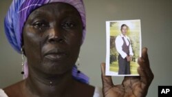 Martha Mark, mère de Monica Mark, pleure alors qu'elle montre la photographie de sa fille, dans la maison familiale à Chibok au Nigeria en mai 2014.