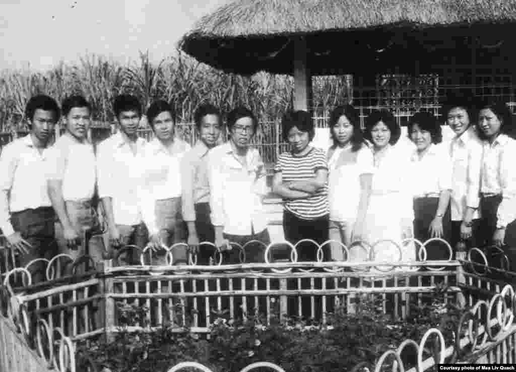 ក្នុង​រូប​ថត​ស​ខ្មៅ​នេះ លោក គួជ មាលីវ (កណ្តាល​ពី​ខាង​ឆ្វេង) ថតរូប​ជាមួយ​ជន​ភៀស​ខ្លួន​ខ្មែរ​មួយ​ក្រុម​ដែល​បាន​រៀន​ភាសា​អង់គ្លេស​ពី​រូប​លោក នៅ​ក្នុង​ឱកាស​ប្រារព្ធ​ពិធី​ចូលឆ្នាំ​ថ្មី​តាម​ប្រតិទិន​ច័ន្ទគតិ នៅ​ជំរំ Minh Tan 1 ប្រទេស​វៀតណាម កាល​ពី​ឆ្នាំ ១៩៨៥។ ជន​ភៀស​ខ្លួន​ភាគ​ច្រើន​នៅ​ជំរំ​នេះ រួម​ទាំង​លោក គួជ មាលីវ ផង ​គឺជា​ពលរដ្ឋ​ខ្មែរ​កាត់​ចិន។ (រូបថត​ផ្តល់​ឲ្យដោយ​លោក គួជ មាលីវ)