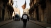 Un hombre con una máscara de Guido Fawkes porta una estelada, la bandera proindependencia catalana, mientras camina el jueves hacia una protesta contra un operativo policial en Barcelona.