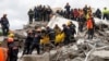 Emergency personnel carry a body during a search for survivors in a collapsed building in Durres, Nov. 28, 2019, after an earthquake shook Albania.