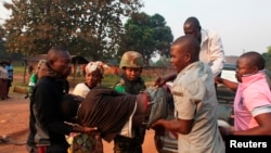A man wounded in overnight clashes is assisted by peacekeepers and family members in a neighborhood in Bangui, Central African Republic, Dec. 23, 2013. 