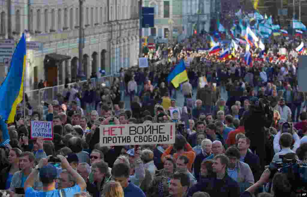 People carry a banner reading "no war against freedom" during an anti-war rally in downtown Moscow, Sept. 21, 2014.