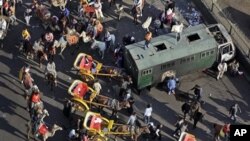 Pro-government demonstrators on horses, camels, and horse-drawn carriages used in the clashes, retreat back past a police truck that was burned in previous clashes a week ago, near Tahrir square in Cairo, Egypt, February 02, 2011.