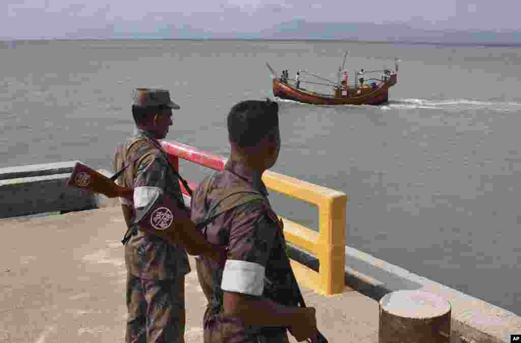 Bangladeshi Border Guard soldiers keep watch at a wharf in Taknaf, Bangladesh, June 12, 2012.