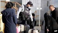 Un policía conversa con una familia que intenta cruzar sin la documentación necesaria la frontera suroeste de Canadá, en marzo pasado. Ese país anunció un programa migratorio con fines humanitarios para beneficiar a 11.000 venezolanos, colombianos y haitianos.