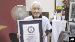 Shitsui Hakoishi, de 108 años, posa con el certificado de Guinness World Records que la reconoce como la barbera más anciana del mundo, en su barbería de Nakagawa, en la prefectura de Tochigi, en el este de Japón, el miércoles 5 de marzo de 2025. AP