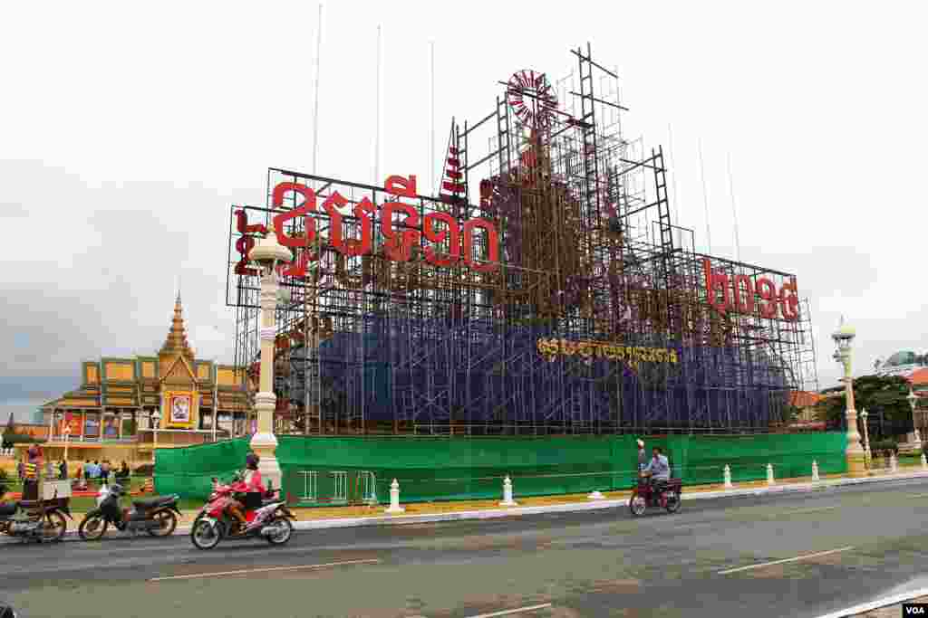 Construction workers in front of the Royal Palace in Phnom Penh prepare the display for the king's 10th anniversary celebration, October 25, 2014. (Nov Povleakhena/VOA Khmer)