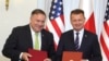 Državni sekretar SAD Majk Pompeo (levo) i poljski ministar odbrane Marius Blaščak poziraju reporterima nakon potpisivanja amerčko-poljksog Unapređenog sporazuma o odbrabenoj saradnji, u Predsedničkoj palati u Vašravi, Poljska, 15. avgusta 2020.
