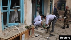 Afghan officials inspect the site of a suicide bomb attack outside a Shi'ite mosque in Herat, Afghanistan, March 25, 2018. 