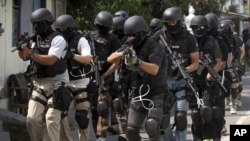Members of Indonesian police anti-terror unit Special Detachment 88 move into positions as they prepare for a raid in Solo, Central Java, Indonesia, September 26, 2012.