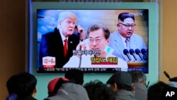 Para pengunjung stasiun kereta Seoul, Korea Selatan, menyaksikan penayangan berita yang menampilkan gambar pemimpin Korea Utara Kim Jong-un (kanan), Presiden Korea Selatan, Moon Jae-in (tengah) dan Presiden AS Donald Trump, 7 Maret 2018. (Foto: dok).