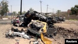 Beberapa kendaraan hancur terlihat di TKP bom bunuh diri di Khalis, sebelah utara Baghdad, Irak Senin (25/7).