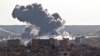 Smoke rises over the Syrian city of Kobani, following a US led coalition airstrike, seen from outside Suruc, on the Turkey-Syria border, Nov. 10, 2014. Kobani, also known as Ayn Arab, and its surrounding areas, has been under assault by extremists of the Islamic State group since mid-September and is being defended by Kurdish fighters. (AP Photo/Vadim Ghirda)