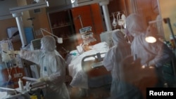 Para petugas medis mengenakan pakaian pelindung khusus saat menangani pasien terinfeksi virus corona di RS Casalpalocco, Roma, Italia, 24 Maret 2020. 