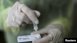 FILE - A health care worker holds a rapid COVID-19 antigen test at a coronavirus testing center in Nice, France, Oct. 15, 2020. Millions of such kits are heading to Africa for distribution.