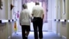 FILE - An elderly couple walks down a hall in Easton, Pennsylvania, Nov. 6, 2015. 