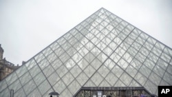 Tourists stand outside the Louvre museum, in Paris, France, March 1, 2020. 