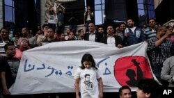 FILE - A girl stands in front of a banner written in Arabic that reads "remove our shackles," during a protest in front of the Press Syndicate in Cairo, Egypt, May 3, 2016. Egyptian authorities broadened their media blackout Sunday to include the website of prominent financial newspaper Al-Boursa.