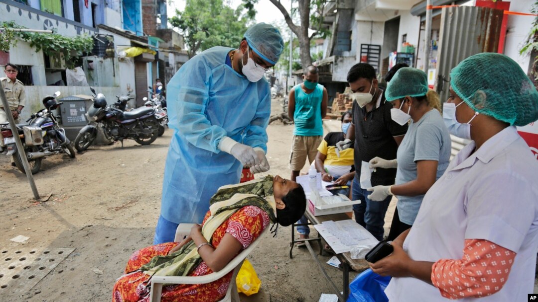 အိန္ဒိယနိုင်ငံ Ahmedabad မြို့မှာ ဒေသခံတွေကို COVID-19 ကူးစက်မှုရှိမရှိ စစ်ဆေးဖို့ Swab နမူနာယူနေတဲ့ ကျန်းမာရေးဝန်ထမ်း။ (စက်တင်ဘာ ၆၊ ၂၀၂၀)
