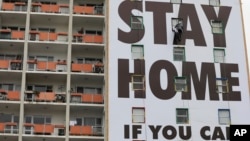 Sebuah pesan untuk tetap tinggal di rumah di gedung apartemen di Cape Town, Afrika Selatan, 25 Maret 2020. Negara tersebut memberlakukan masa karantina 21 hari untuk menghentikan penyebaran corona, mulai Kamis (26/3) tengah malam.