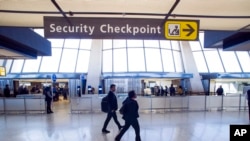 FILE - Sign points to a Transportation Security Administration checkpoint at Dulles International Airport in Dulles, Va., March 26, 2019.