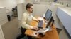 FILE- Josh Baldonado, an administrative assistant at Brown & Brown Insurance, works at a treadmill desk in the firms offices in Carmel, Indiana, Aug. 28, 2013.
