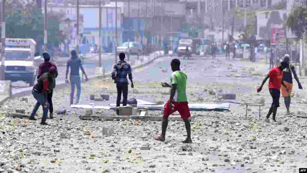 Des étudiants lancent des pierres sur la police sénégalaise lors d'une manifestation devant les portes de l'Université Cheikh Anta Diop de Dakar le 16 mai 2018