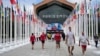 Los participantes de los Juegos Olímpicos y Paralímpicos de París 2024 caminan frente a la cafetería de la Villa Olímpica, en Saint-Denis, al norte de París, el 22 de julio de 2024, antes de la ceremonia de apertura de los Juegos Olímpicos y Paralímpicos de París 2024.