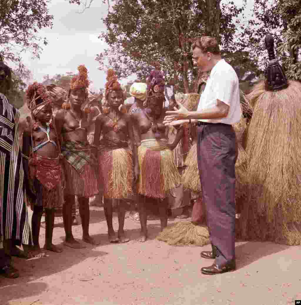 L'évangéliste américain Billy Graham parle avec les femmes d'un petit village au Ghana, en janvier 1960.