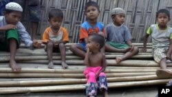Anak-anak Rohingya yang tampak kekurangan gizi duduk di atas tumpukan bambu di kamp Dar Paing, utara Sittwe, negara bagian Rakhine, Myanmar (foto: ilustrasi).