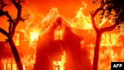Uma casa é engolida pelas chamas durante o incêndio de Eaton na área de Altadena, no condado de Los Angeles, Califórnia, a 8 de janeiro de 2025. 