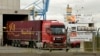 Spanduk bertuliskan 'Brexit proof' dipasang di pagar pengaman saat sebuah truk melewati terowongan pemindaian di Pelabuhan Zeebrugge, di Zeebrugge, Belgia, Kamis, 24 Oktober 2019. (Foto: AP)