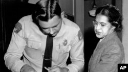 FILE - In this Feb. 22, 1956, photo, Rosa Parks is fingerprinted by police Lt. D.H. Lackey in Montgomery, Alabama, after refusing to give up her seat on a bus for a white passenger Dec. 1, 1955.