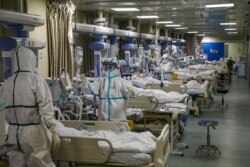 Medical workers in protective suits attend to novel coronavirus patients at the intensive care unit (ICU) of a designated hospital in Wuhan, Hubei province, China, Feb. 6, 2020. (Credit: China Daily)