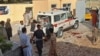 Hombres afganos junto a una ambulancia después de un ataque con bomba en una mezquita en Kunduz el 8 de octubre de 2021.