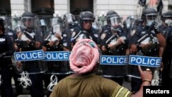 Un manifestante hace un gesto hacia los agentes del Departamento de Policía de Nueva York (NYPD) en apoyo de "Black Lives Matter" en la ciudad de Nueva York, EE.UU. 