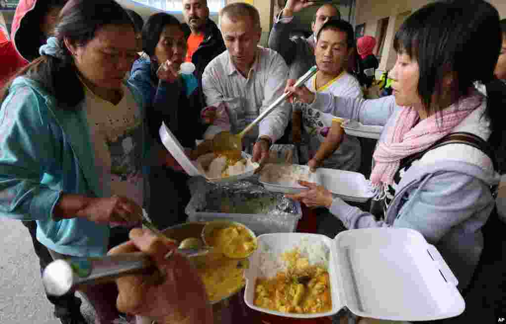 Supporters give warm food to migrants arriving at the Westbahnhof station in Vienna, Austria, Sept. 7, 2015.
