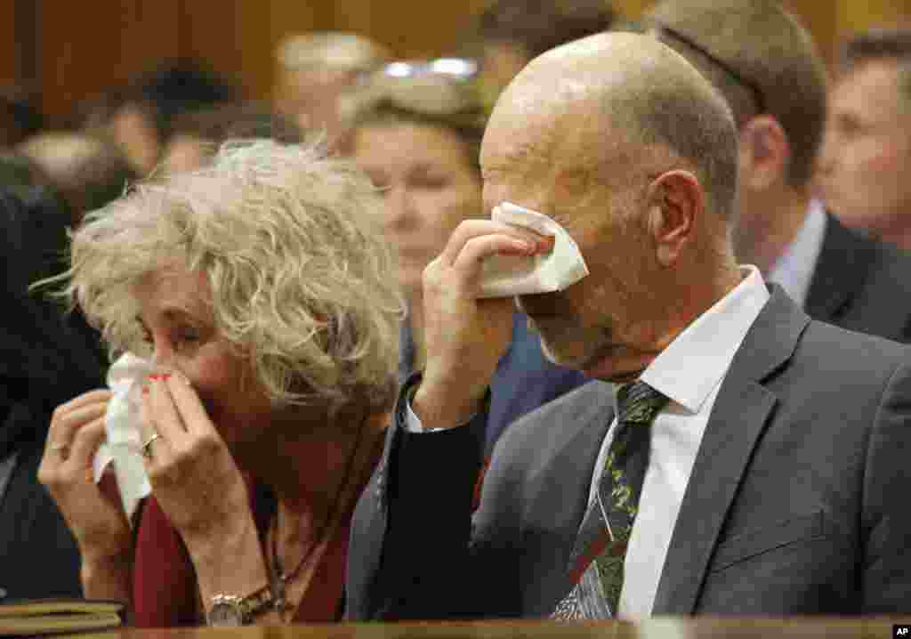 Family members, including uncle Arnold Pistorius, right, cry as they listen to Oscar Pistorius testifying in court in Pretoria, April 8, 2014.