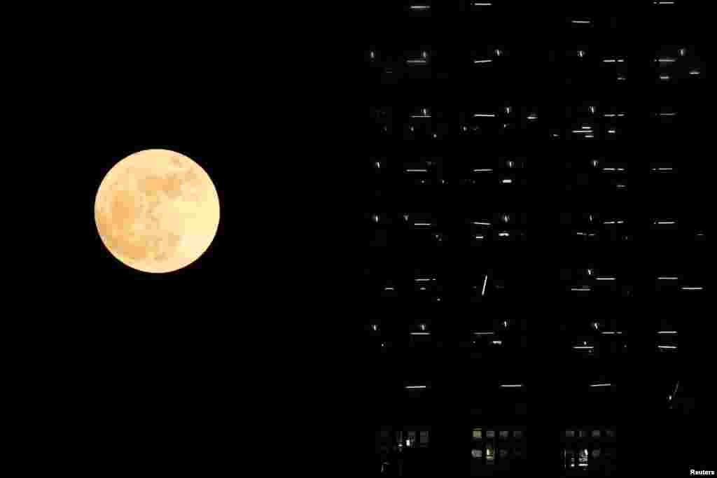 Bulan purnama 'supermoon' terlihat di belakang gedung yang belum selesai dibangun di Hong Kong.