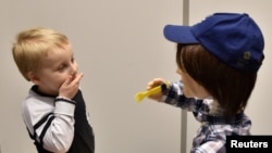 Harrison, 5, who is autistic, plays with Kaspar, a child-sized humanoid robot developed at the University of Hertfordshire to interact and help improve the lives of children with autism, in Stevenage, Britain, Jan. 30, 2017.